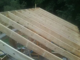 New roof rafters set over an addition before sheathing in Hood