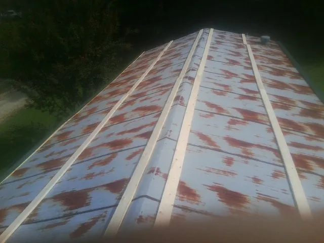Rusted metal roof panels with new wood purlins before replacement — Storm Damage Roof Repair in Hood by Roofing Brothers
