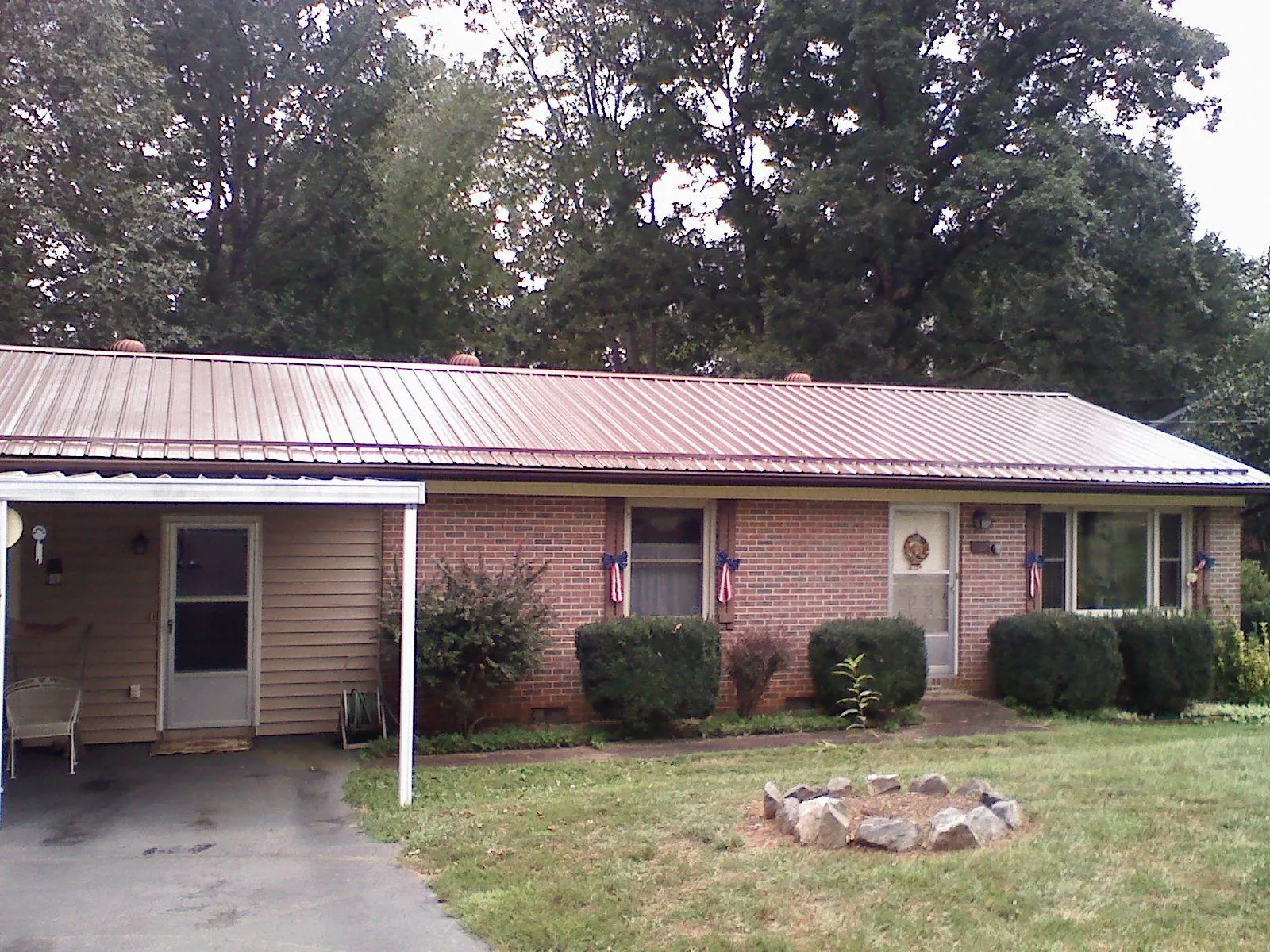 Bronze metal roof and carport on a brick ranch home — Roof Repair work by our crew in Hood