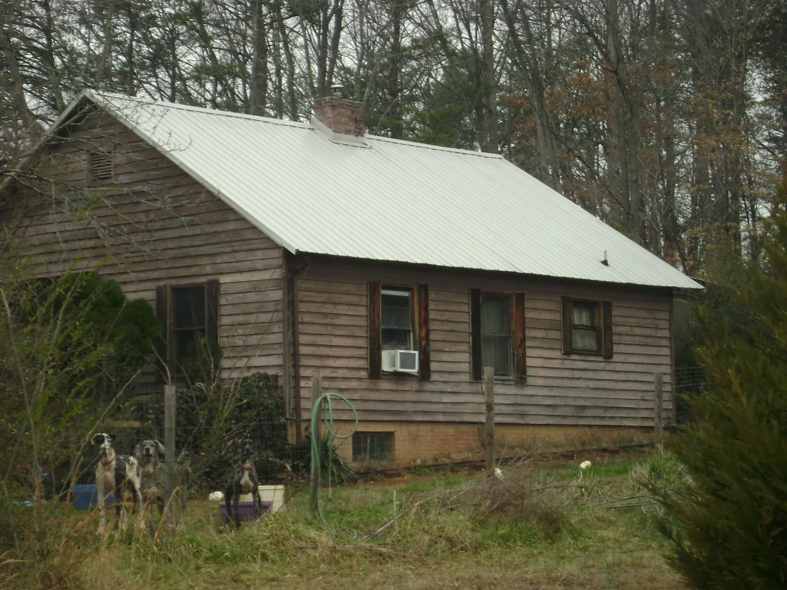 White metal roof on an old wood sided farmhouse, from a Metal Roof Installation job in Hood